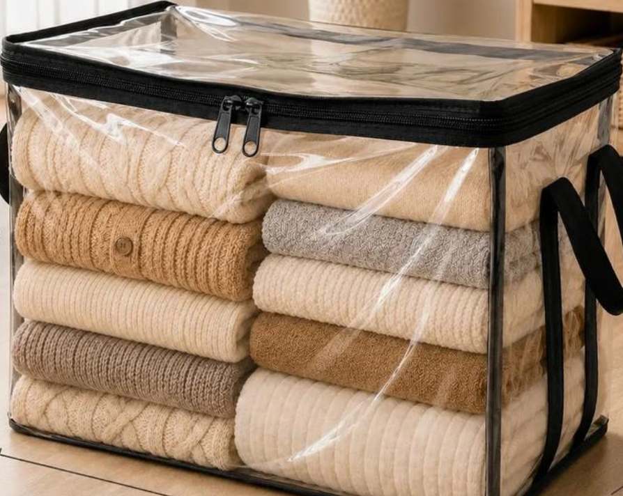 CLARA clear storage bag filled with folded sweaters